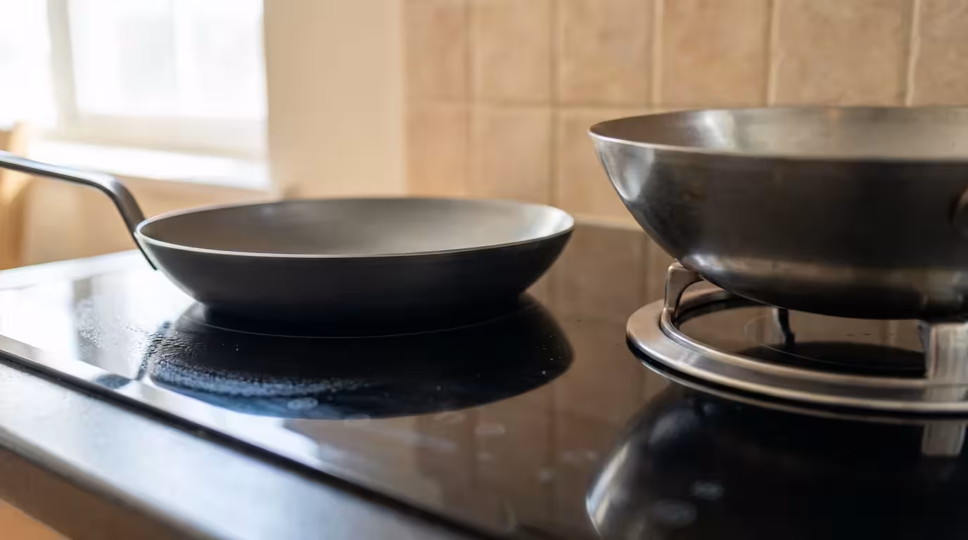 Close-up photo comparing a flat-bottom wok and round-bottom wok on an electric stove.